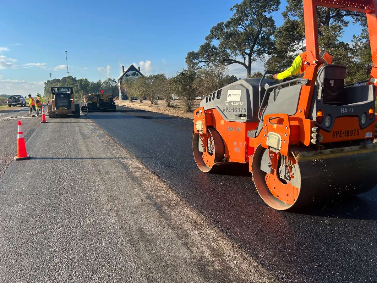 AAA Paving roller and crew compacting fresh asphalt on a commercial paving project in Texas