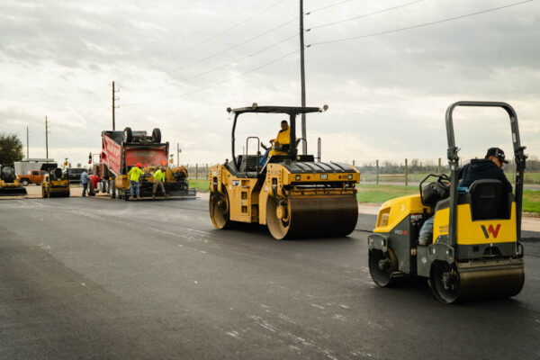 AAA Paving heavy machinery working on new asphalt road.