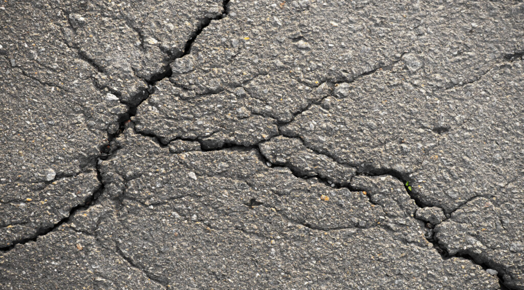 Close-up of a road with cracks as a background.