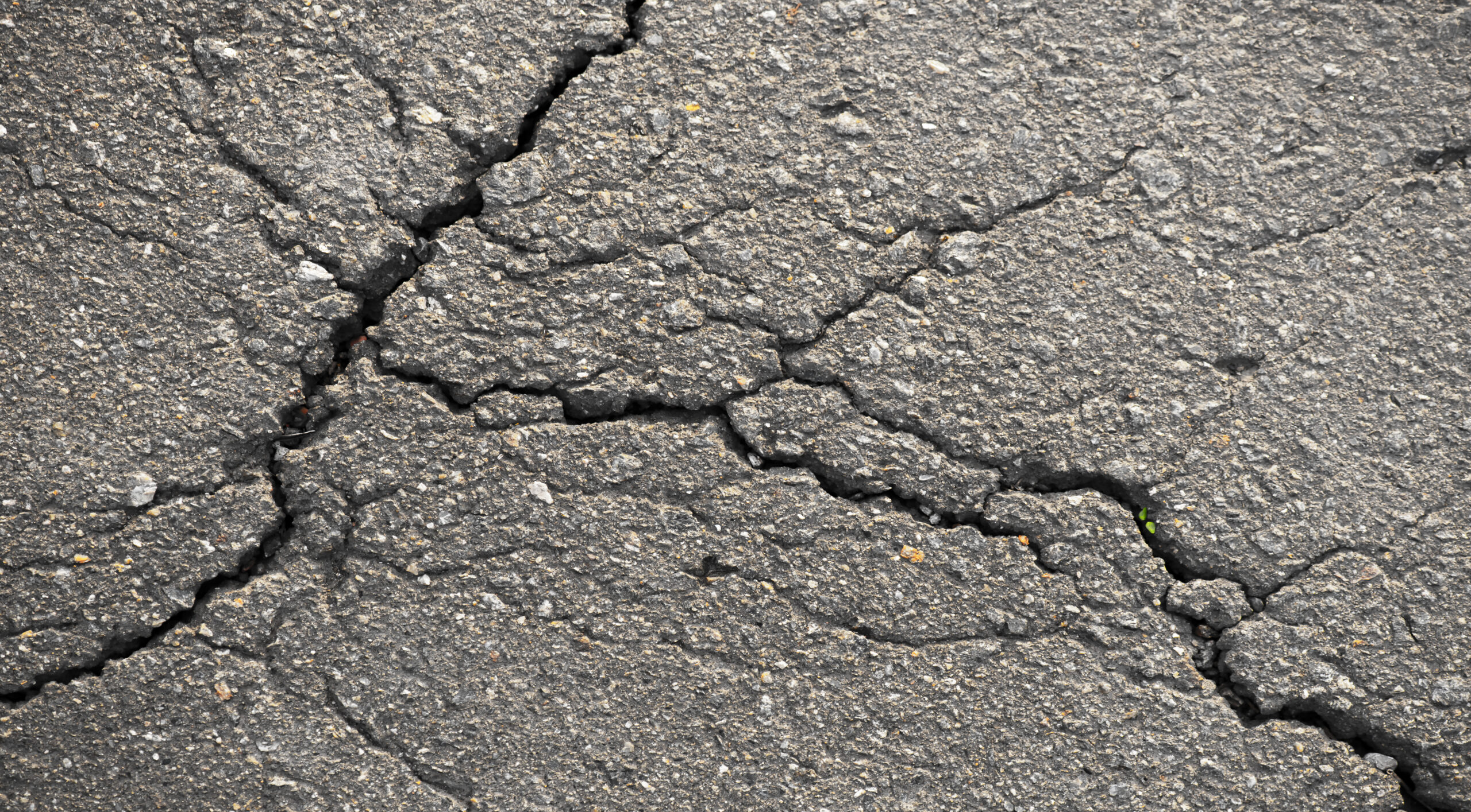 Close-up of a road with cracks as a background.